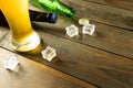 Image of beer bottles, ice cubes and pint glass of beer on wooden table, with copy space Royalty Free Stock Photo