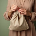 Image Beige setting, a womans hand secures a subsidy canvas bag