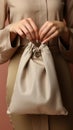 Image Beige setting, a womans hand secures a subsidy canvas bag