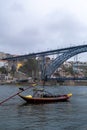 Image from below of the Dom Luis I bridge with a small boat in front on the Porto river