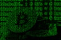 Image of the binary code from bright green digits, through which the image of the physical bitcoin Royalty Free Stock Photo