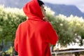 Image of biracial man in red hooded top with copyspace over trees in background Royalty Free Stock Photo