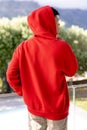 Image of biracial man in red hooded top with copyspace over trees in background Royalty Free Stock Photo