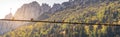 Image of birds sitting on a power line with sunset and mountainlandscape in the background