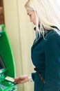 Image of blonde in coat at green cash machine Royalty Free Stock Photo