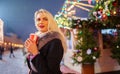 Image of blonde woman with glass in hands against background of burning garlands in street Royalty Free Stock Photo