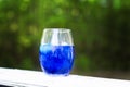 Image of a blue cocktail on a porch railing in front of the sunset Royalty Free Stock Photo