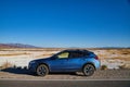 Blue Subaru Crosstrek parked on road with white sand desert in background outside Death Valley