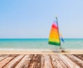 Image of blurred sea blue-sky and colorful boat with coconut wooden plank