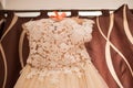 Image of the bodice of a beige wedding dress on a hanger