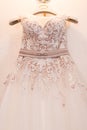 Image of the bodice of a beige wedding dress on a hanger