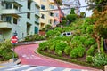 Bottom of Lombard Street with car winding down flower riddled hill toward stop Royalty Free Stock Photo