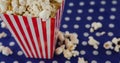 Image of box of popcorn over white spots Royalty Free Stock Photo