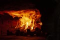 Image of a brick pizza oven with fire.