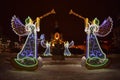 Bright Christmas angels with trumpets on the background of the church