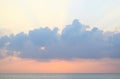 Skyscape at time of Sunset - Crepuscular Bright Sunrays spreading through Clouds with Orange sky at Horizon over Blue Sea Water Royalty Free Stock Photo