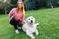 Image of brunette with labrador lying on lawn in summer park