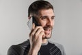 Image of brutal cheerful sportsman talking on cellphone and smiling