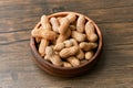 Image of bunch of peanuts in a bowl on a wooden table Royalty Free Stock Photo