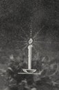 Image of a burning candle on a granite tombstone with a reflection of wreath flowers. Halloween. Royalty Free Stock Photo