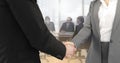 Image of businessman and businesswoman shaking hands over group of businesspeople in office Royalty Free Stock Photo