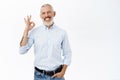 Image of businessman showing okay sign, ok gesture, approve, recommend something awesome, standing against white Royalty Free Stock Photo