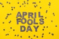 Image caption April Fools' Day of carved letters of grey on a yellow background around scattered confetti