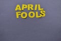 Image caption April pranks of yellow paper letters are laid out on a grey background with a copy space