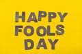 Image caption Happy Fool's Day of grey paper letters on a yellow background close-up