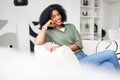 The image captures an African-American woman lounging comfortably at home