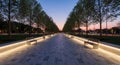 Modern Park Pathway at Dusk with LED Lighting, Benches Symmetrical Trees Royalty Free Stock Photo