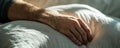 Macro shot of a man& x27;s hand resting on a soft pillow in warm lighting, evoking a sense of comfort and relaxation Royalty Free Stock Photo
