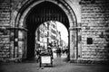 Image captures an expansive arch overlooking a bustling street