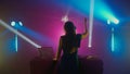 Female DJ Celebrating Music at Nightclub with Colorful Lights