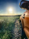 Sunny Rural Escape: Side View of a Car on a Dirt Road at Sunset Royalty Free Stock Photo