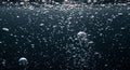 Dense cluster of silver bubbles in dark water Royalty Free Stock Photo