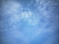 An image capturing the boundless blue sky, featuring soft cloud formations that add texture and depth. Royalty Free Stock Photo