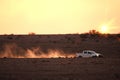 Car on a dusty unsealed road in sunset light mood Royalty Free Stock Photo