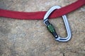 Image of a carabiner hook and red rope on rock Royalty Free Stock Photo