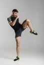 Image of caucasian athletic man in sportswear kicking while working out
