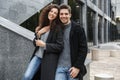 Image of caucasian couple man and woman 20s in warm clothes, standing over gray building outdoor Royalty Free Stock Photo