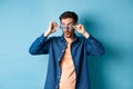 Image of caucasian guy takes-off sunglasses and looking aside with surprised face, checking out empty space for logo Royalty Free Stock Photo