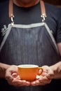 Image of Caucasian man holding with both hands orange cup of coffee. copy space