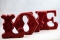 A red ceramic love ornament displayed on a white background