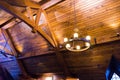 Wooden ceiling and rustic vintage chandelier with electric bulbs. Classic luxury home architecture