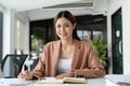 Image of a charming asian woman working calculator at a modern office. looking at camera.