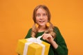Image of charming blonde teen smiling and holding present box with white bow. New Year birthday holiday concept