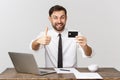 Image of cheerful businessman in suit smiling while holding laptop and credit card isolated over gray background. Royalty Free Stock Photo