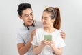 Image of cheerful man smiling while looking at cellphone of his girlfriend isolated overwhite background Royalty Free Stock Photo