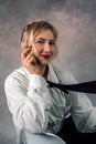 Image of a cheerful office woman with long white hair in business clothes sitting on a chair and looking away Royalty Free Stock Photo